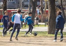 Дети играя футбол в парке на солнечный день стоковые фотографии rf Дети играя футбол в парке на солнечный день стоковые фотографии rf