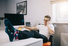 Дизайнер сидит перед окном в рабочем месте Молодой работник имея пролом и отдыхая после разрешать задачу стоковая фотография Дизайнер сидит перед окном в рабочем месте Молодой работник имея пролом и отдыхая после разрешать задачу стоковая фотография