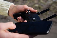 Дистанционное управление и смартфон в мужских руках Человек держа передатчик и пилотируя некоторые корабли Трутень, радио контрол стоковые изображения rf Дистанционное управление и смартфон в мужских руках Человек держа передатчик и пилотируя некоторые корабли Трутень, радио контрол стоковые изображения rf