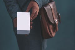 Длинное знамя с насмешкой вверх по белой коробке от смартфона Девушка в пальто и коричневых перчатках держит подарок в его руках стоковая фотография rf Длинное знамя с насмешкой вверх по белой коробке от смартфона Девушка в пальто и коричневых перчатках держит подарок в его руках стоковая фотография rf