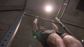 Дно себя крупного плана вверх по всходу взрослого мышечного атлетического человека поднимаясь на барах внутри помещения в спортза видеоматериал Дно себя крупного плана вверх по всходу взрослого мышечного атлетического человека поднимаясь на барах внутри помещения в спортза видеоматериал