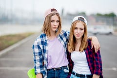 2 довольно усмехаясь белокурых девушки нося checkered рубашки, крышки и шорты джинсовой ткани стоят на пустой автостоянке с стоковая фотография 2 довольно усмехаясь белокурых девушки нося checkered рубашки, крышки и шорты джинсовой ткани стоят на пустой автостоянке с стоковая фотография