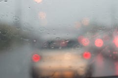 Дождь и вода в нерезкости красного света затора движения Стоковые Изображения Дождь и вода в нерезкости красного света затора движения Стоковые Изображения