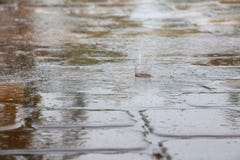 Дождевые капли Splattering на плитках палубы бассейна Стоковая Фотография RF Дождевые капли Splattering на плитках палубы бассейна Стоковая Фотография RF