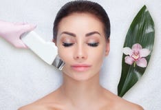 Доктор-cosmetologist делает процедуру по чистки ультразвука лицевой кожи красивого, молодой женщины в салоне красоты стоковое фото Доктор-cosmetologist делает процедуру по чистки ультразвука лицевой кожи красивого, молодой женщины в салоне красоты стоковое фото