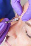 Доктор Giving Botox косметического хирурга к старшей стороне женщины стоковые изображения rf Доктор Giving Botox косметического хирурга к старшей стороне женщины стоковые изображения rf