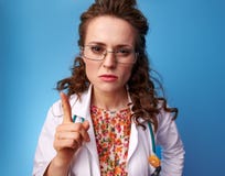Доктор Paediatrist угрожая с пальцем на сини Стоковое фото RF Доктор Paediatrist угрожая с пальцем на сини Стоковое фото RF