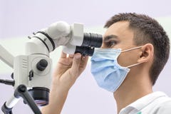 Доктор используя зубоврачебный микроскоп стоковые изображения Доктор используя зубоврачебный микроскоп стоковые изображения