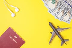 100 долларовых банкнот, самолет, наушники, чужой паспорт на яркой желтой бумажной предпосылке скопируйте космос стоковая фотография rf 100 долларовых банкнот, самолет, наушники, чужой паспорт на яркой желтой бумажной предпосылке скопируйте космос стоковая фотография rf