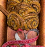 домодельные сладостные крены циннамона на красной плите с ручками cinnamons и рулетки пустыни Стоковая Фотография домодельные сладостные крены циннамона на красной плите с ручками cinnamons и рулетки пустыни Стоковая Фотография