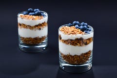 Домодельный испеченный granola с югуртом и голубиками в стекле дальше стоковые фотографии rf Домодельный испеченный granola с югуртом и голубиками в стекле дальше стоковые фотографии rf