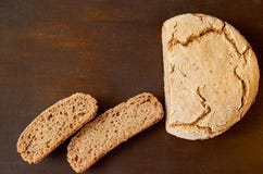 Домодельный отрезанный свежий хлеб на деревянной предпосылке Как раз испеченный вокруг хлеба на коричневой таблице с космосом бес Стоковая Фотография RF Домодельный отрезанный свежий хлеб на деревянной предпосылке Как раз испеченный вокруг хлеба на коричневой таблице с космосом бес Стоковая Фотография RF