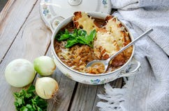 Домодельный французский луковый суп с сыром и тостом на деревянной предпосылке стоковое фото rf Домодельный французский луковый суп с сыром и тостом на деревянной предпосылке стоковое фото rf