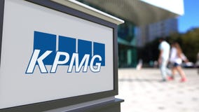 Доска signage улицы с логотипом KPMG Запачканный центр офиса и идя предпосылка людей Редакционный перевод 3D стоковое изображение rf Доска signage улицы с логотипом KPMG Запачканный центр офиса и идя предпосылка людей Редакционный перевод 3D стоковое изображение rf