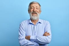 Дружелюбное красивое положение человека с пересеченными оружиями, смеясь на что-то стоковое изображение rf Дружелюбное красивое положение человека с пересеченными оружиями, смеясь на что-то стоковое изображение rf