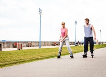 Друзья rollerblading совместно имеют потеху в парке Стоковые Фотографии RF Друзья rollerblading совместно имеют потеху в парке Стоковые Фотографии RF