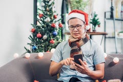 Друзья звонка азиатской пользы шляпы santa носки человека передвижные и сидеть дальше стоковое изображение rf Друзья звонка азиатской пользы шляпы santa носки человека передвижные и сидеть дальше стоковое изображение rf