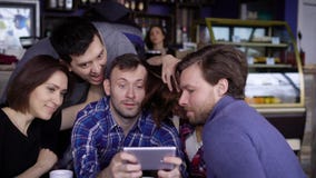 Друзья сидя на таблице в кафе совместно тратя часы досуга совместно и используя цифровое устройство 3 красивое видеоматериал Друзья сидя на таблице в кафе совместно тратя часы досуга совместно и используя цифровое устройство 3 красивое видеоматериал