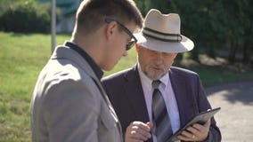 2 делового партнера говоря и используя таблетки outdoors 4K 2 делового партнера говоря и используя таблетки outdoors 4K