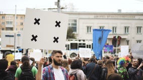 Европейские люди на демонстрации Человек с знаменем кричащим в мундштук Европейские люди на демонстрации Человек с знаменем кричащим в мундштук
