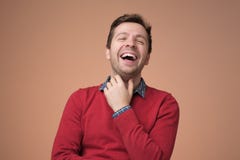 Европейский молодой человек в красном свитере смеясь на смешной шутке стоковые фотографии rf Европейский молодой человек в красном свитере смеясь на смешной шутке стоковые фотографии rf