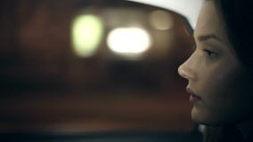 Езды девушки в такси на ноче Закройте вверх с bokeh Езды девушки в такси на ноче Закройте вверх с bokeh