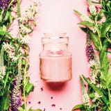 Естественная травяная концепция косметики заботы кожи Стеклянный опарник с cream и свежими травами и цветками на розовой предпосы Стоковое Фото Естественная травяная концепция косметики заботы кожи Стеклянный опарник с cream и свежими травами и цветками на розовой предпосы Стоковое Фото