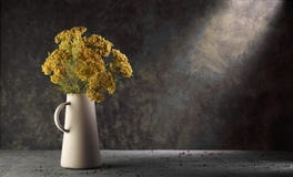 Желтые цветки в вазе на темной предпосылке с драматическим светом стоковая фотография rf Желтые цветки в вазе на темной предпосылке с драматическим светом стоковая фотография rf