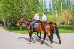 Женская конная полиция на задней части лошади в городе паркует стоковое фото Женская конная полиция на задней части лошади в городе паркует стоковое фото