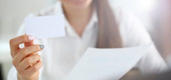Женская рука в костюме дает пустую телефонную карточку посетителю стоковое изображение rf Женская рука в костюме дает пустую телефонную карточку посетителю стоковое изображение rf