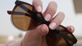 Женская рука с красивым маникюром держит концепцию заботы руки солнечных очков, моды и красоты стоковые фото Женская рука с красивым маникюром держит концепцию заботы руки солнечных очков, моды и красоты стоковые фото