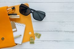 E Женские вещи, косметические продукты, sunglass, тетрадь и оранжевая сумка на деревянной предпосылке с copyspace r стоковые изображения rf E Женские вещи, косметические продукты, sunglass, тетрадь и оранжевая сумка на деревянной предпосылке с copyspace r стоковые изображения rf