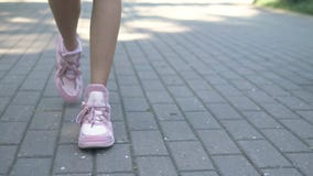 : женские ноги в стильных розовых тапках девушка идя на улицу с мостовой Естественный солнечный дневной свет стоковая фотография : женские ноги в стильных розовых тапках девушка идя на улицу с мостовой Естественный солнечный дневной свет стоковая фотография