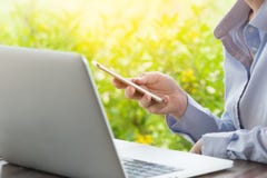 Женские руки используя современный умный телефон пока работающ на офисе с компьютером, текстовым сообщением коммерсантки печатая стоковое изображение rf Женские руки используя современный умный телефон пока работающ на офисе с компьютером, текстовым сообщением коммерсантки печатая стоковое изображение rf