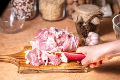 Женские руки с ножом в их руке отрезали свежее мясо на деревянной доске стоковое фото rf Женские руки с ножом в их руке отрезали свежее мясо на деревянной доске стоковое фото rf