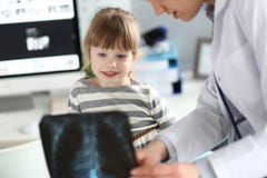 Женский paediatrician работая с милой маленькой девочкой на ее офисе объясняя диагноз стоковое изображение rf Женский paediatrician работая с милой маленькой девочкой на ее офисе объясняя диагноз стоковое изображение rf