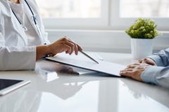 Женский доктор рекомендует заполнить внутри медицинский документ стоковое изображение rf Женский доктор рекомендует заполнить внутри медицинский документ стоковое изображение rf