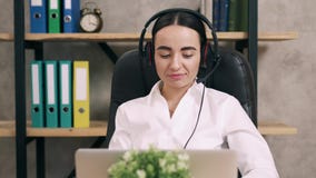 Женский работник центра телефонного обслуживания отвечает звонку клиента в офисе Женский работник центра телефонного обслуживания отвечает звонку клиента в офисе