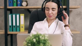 Женский работник центра телефонного обслуживания отвечает звонку клиента в офисе Женский работник центра телефонного обслуживания отвечает звонку клиента в офисе