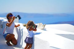 2 женских туриста, мать и дочь, делают фотографии Oia, в Santorini стоковая фотография rf 2 женских туриста, мать и дочь, делают фотографии Oia, в Santorini стоковая фотография rf