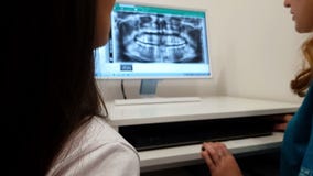 Женское stomatologist показывая терпеливые зубы рентгенизирует изображение на компьютере, диагноз стоковое изображение Женское stomatologist показывая терпеливые зубы рентгенизирует изображение на компьютере, диагноз стоковое изображение