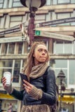 Женское туристское положение перед дорожными знаками города стоковые изображения Женское туристское положение перед дорожными знаками города стоковые изображения