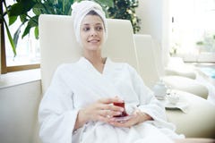 Женщина в купальном халате ослабляя бассейном в КУРОРТЕ стоковые изображения Женщина в купальном халате ослабляя бассейном в КУРОРТЕ стоковые изображения