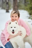 Женщина в лесе зимы идя с собакой Снежок падает стоковое изображение rf Женщина в лесе зимы идя с собакой Снежок падает стоковое изображение rf