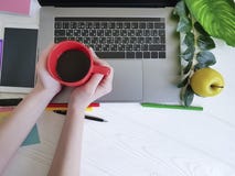 Женщина взгляд сверху настольного компьютера вручает работе белую деревянную дизайнерскую кофейную чашку стоковые фотографии rf Женщина взгляд сверху настольного компьютера вручает работе белую деревянную дизайнерскую кофейную чашку стоковые фотографии rf