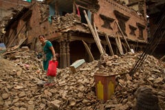 Женщина вне ее теперь землетрясения загубила дом в Bhaktapur, Ne стоковые фотографии rf Женщина вне ее теперь землетрясения загубила дом в Bhaktapur, Ne стоковые фотографии rf
