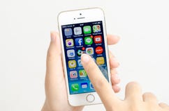 Женщина вручает держать и касаться iPhone 5s Яблока стоковое фото Женщина вручает держать и касаться iPhone 5s Яблока стоковое фото
