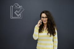 Женщина говоря на телефоне перед предпосылкой с вычерченными диаграммами дела Стоковые Фото Женщина говоря на телефоне перед предпосылкой с вычерченными диаграммами дела Стоковые Фото
