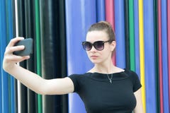 Женщина делает selfie с smartphone в Париже, Франции Женщина с мобильным телефоном на красочной предпосылке Девушка в солнечных о стоковое изображение Женщина делает selfie с smartphone в Париже, Франции Женщина с мобильным телефоном на красочной предпосылке Девушка в солнечных о стоковое изображение
