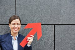 Женщина дела держа красную стрелку вверх стоковое фото rf Женщина дела держа красную стрелку вверх стоковое фото rf